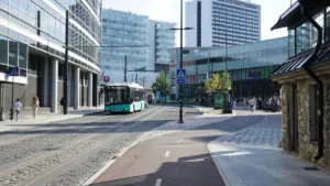 Moodne buss sõitmas mööda Tallinna kesklinna tänavat, kus asuvad ärihooned.