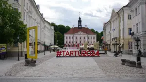 Tartu Raekoja plats koos Tartu 2024 sildiga suvisel ja päikeselisel päeval.