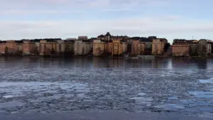 Jäätunud veekogu ja linnavaade, mis sümboliseerib uue elupiirkonna potentsiaali ja arengut.