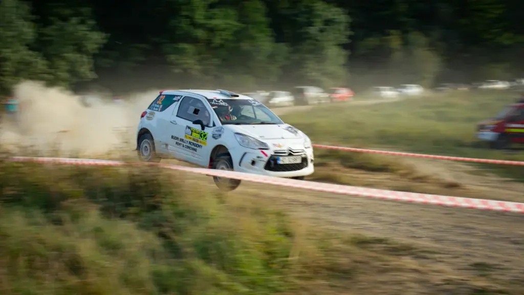 Ralliauto sõitmas tolmukel keerleval kruusateel Paide ralli võistluse ajal Eestis.
